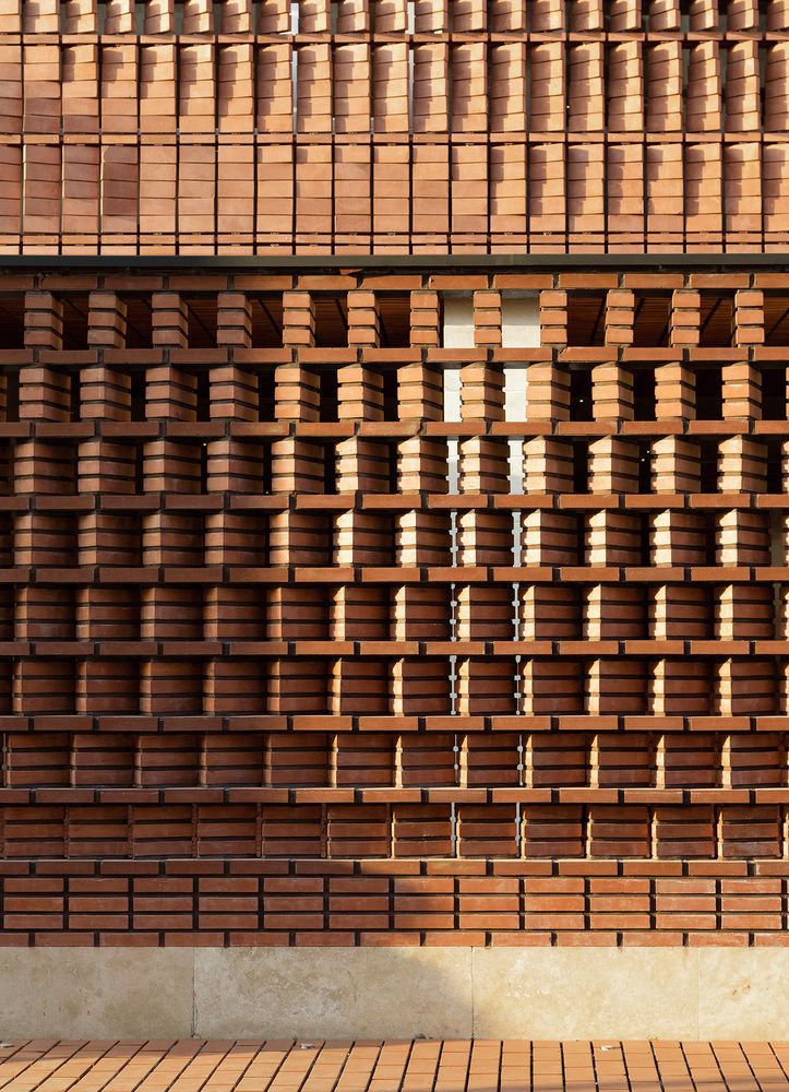 a building with wooden slats on the side and a bench in front of it