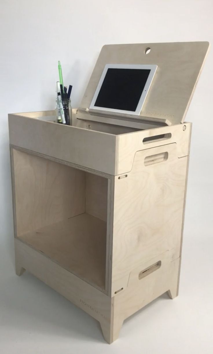 an open laptop computer sitting on top of a wooden desk with drawers and shelves underneath