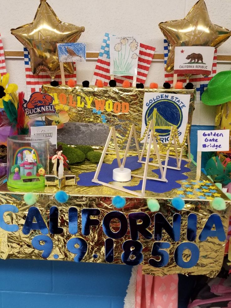 a table topped with lots of decorations on top of a blue counter covered in gold foil