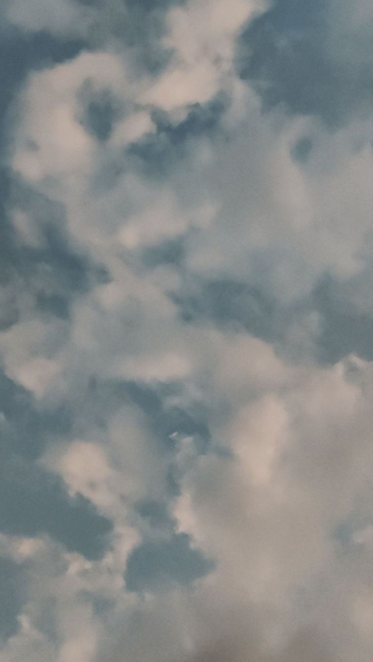 an airplane is flying through the cloudy sky