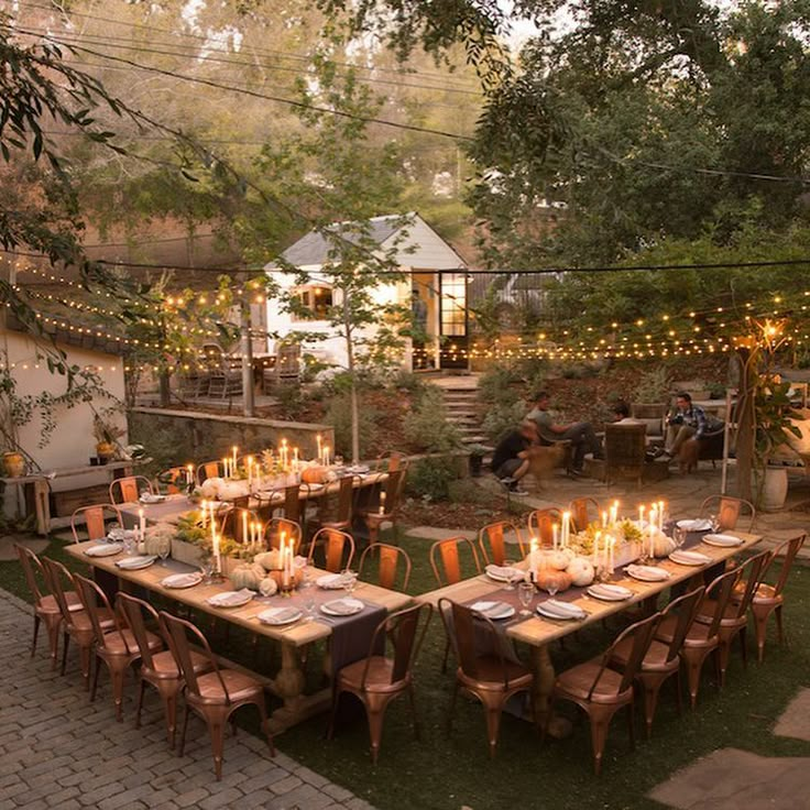 an outdoor dining area is set up for dinner with candles lit on the tables and chairs