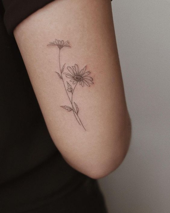 a woman's arm with a flower tattoo on the back of her left arm