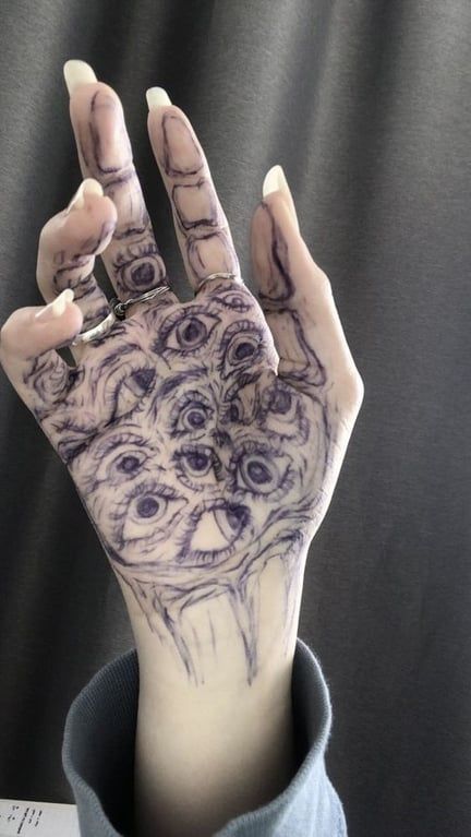 a person's hand with tattoos on it that has an animal face drawn on the palm