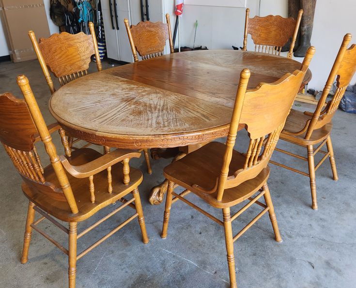 a large wooden table with six chairs around it in a room filled with other furniture