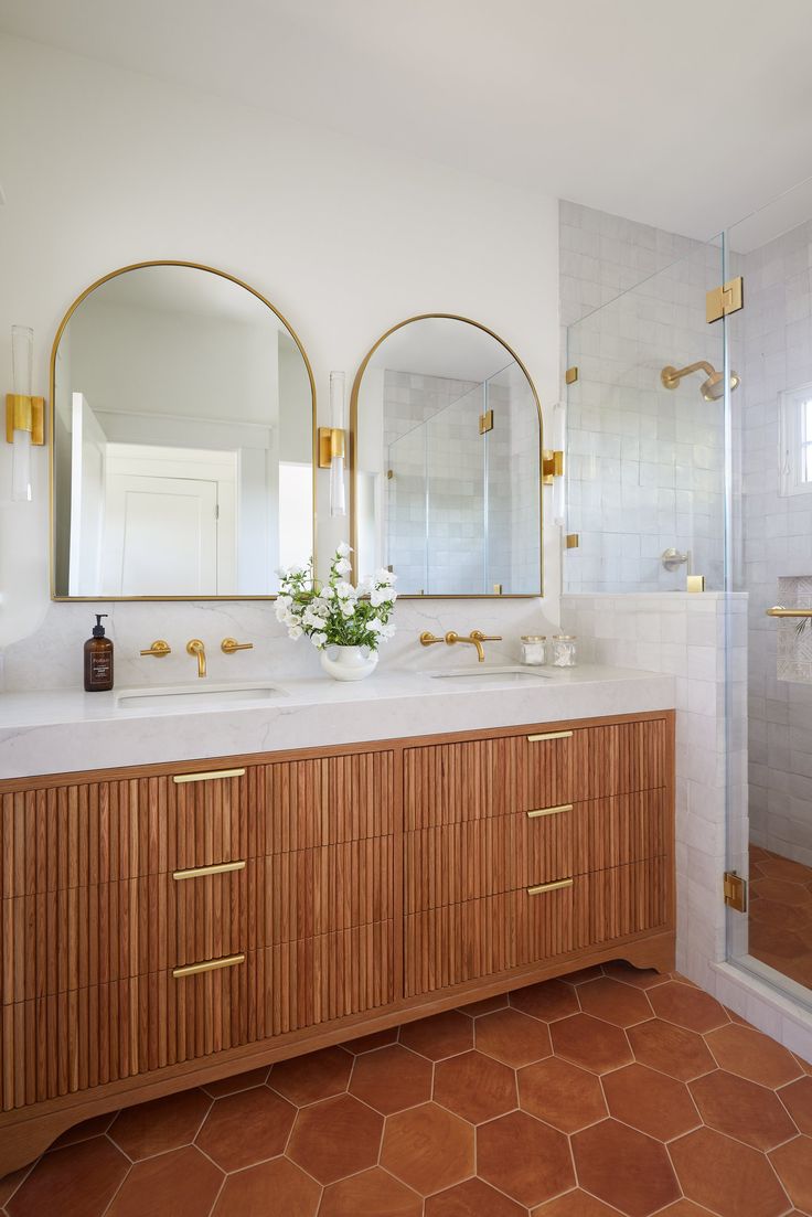 a bathroom with two sinks and mirrors in it