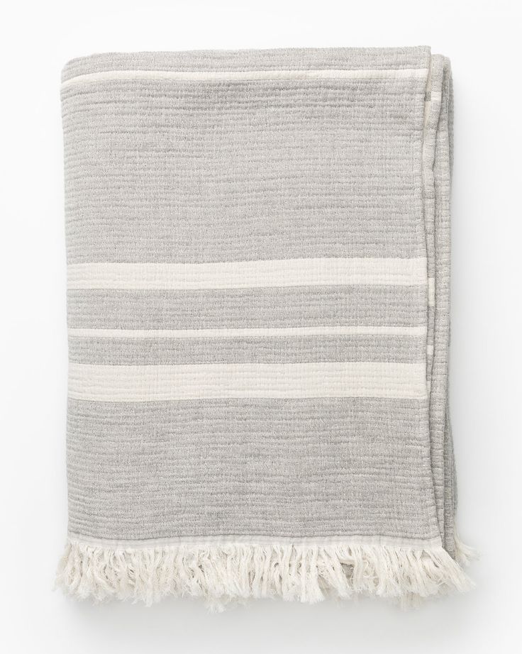 a gray and white striped blanket with fringes