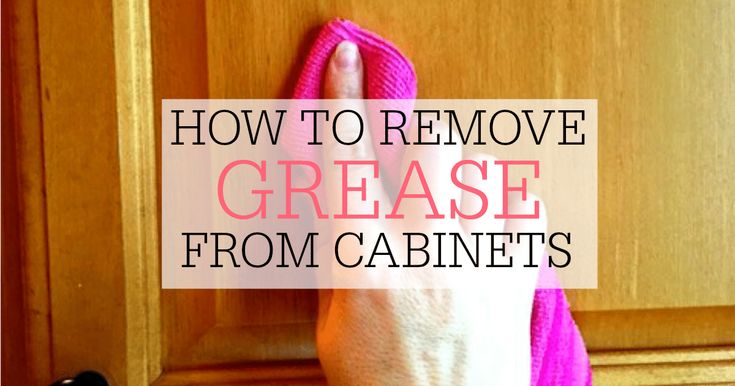 a hand holding a pink towel in front of a kitchen cabinet with the words how to remove grease from cabinets