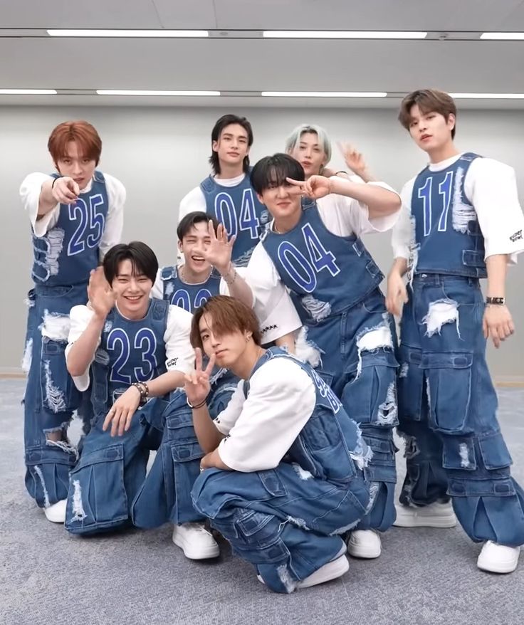 a group of young men posing for a photo in denim overalls and white t - shirts