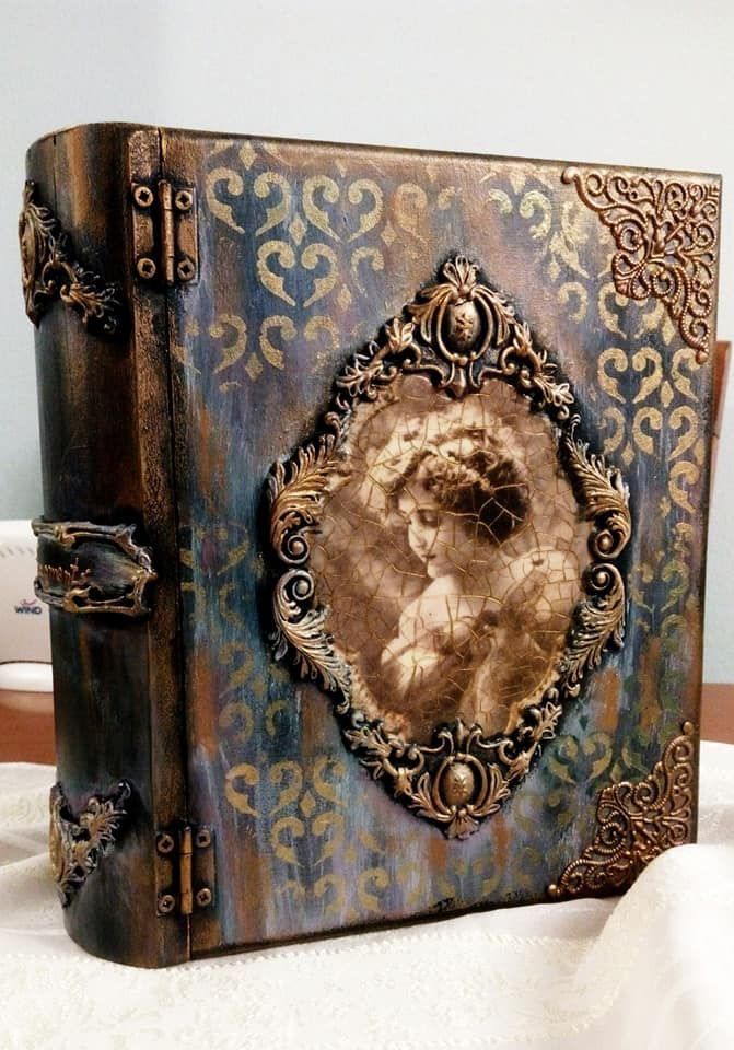 an altered book with a woman's face on the front cover and ornate gold trimmings