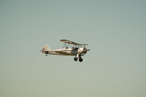 an old airplane flying in the sky on a clear day