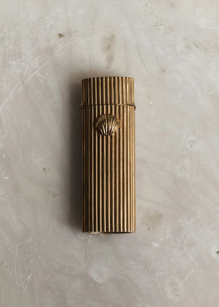 a gold lighter sitting on top of a white counter