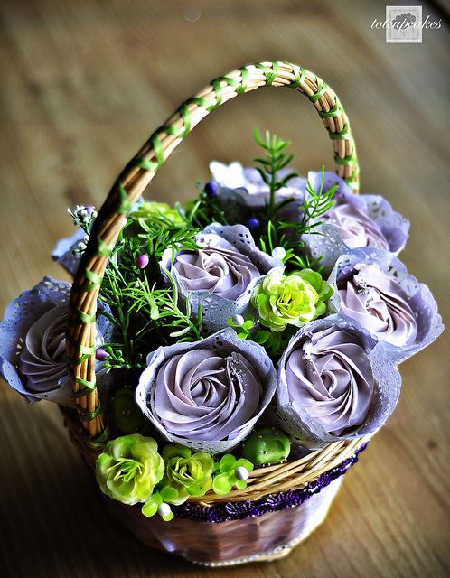 a basket filled with flowers sitting on top of a wooden table