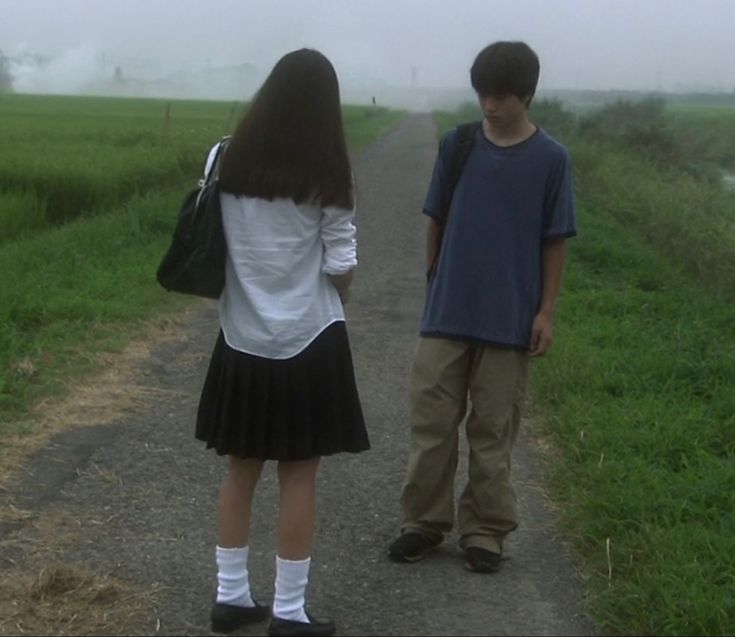 two children are standing on a path in the rain