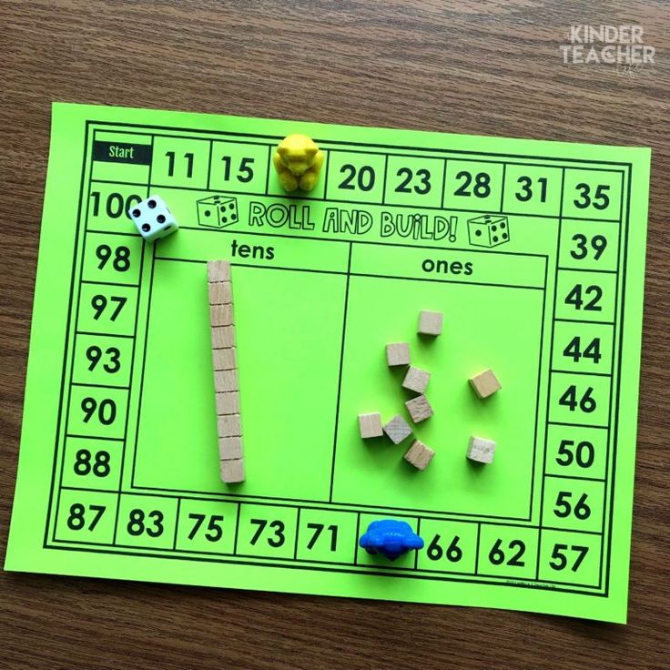 a green board with dices and blocks on it, next to a blue toy