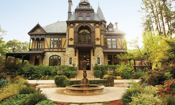 a large house with a fountain in front of it