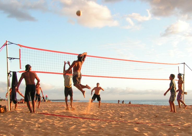 several people playing volleyball on the beach