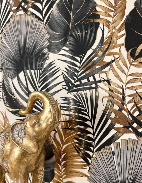 an elephant statue in front of a gold and black wallpaper with palm leaves on it