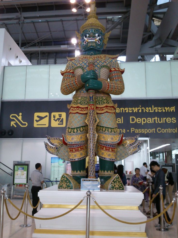 an elaborately decorated statue in the middle of a building with people standing around it