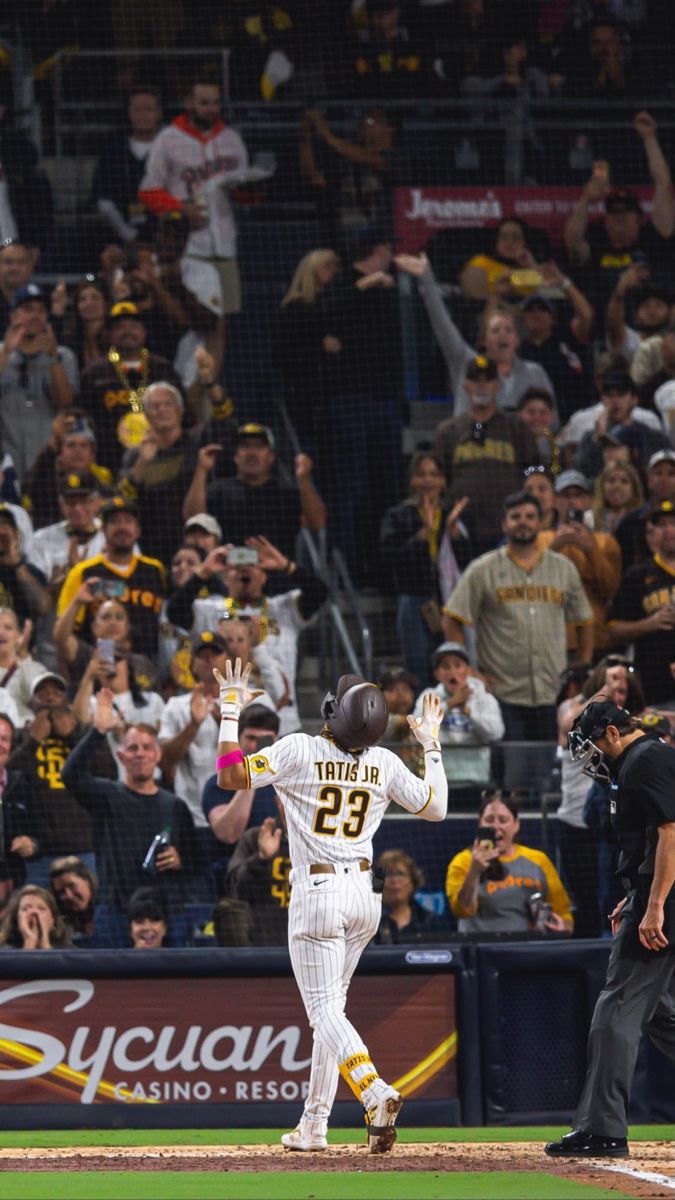 a baseball player standing on top of a field next to home plate in front of a crowd