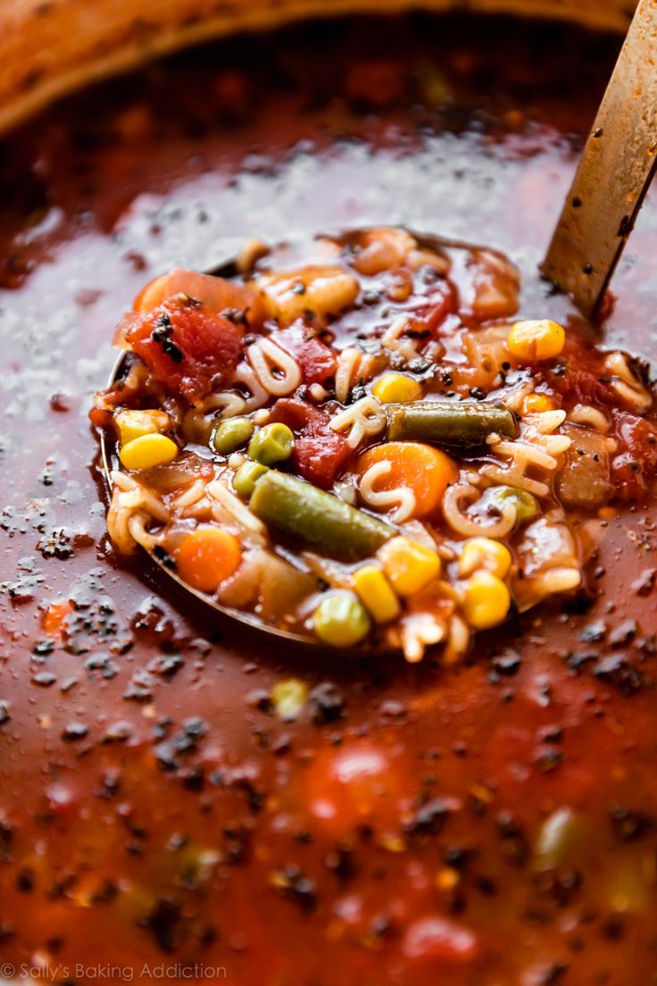 a spoon full of soup with noodles and vegetables