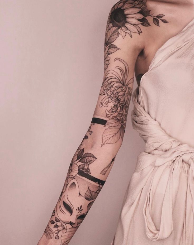 a woman with tattoos on her arm and hand