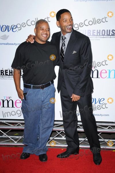 two men standing next to each other on a red carpet at an event with one man smiling