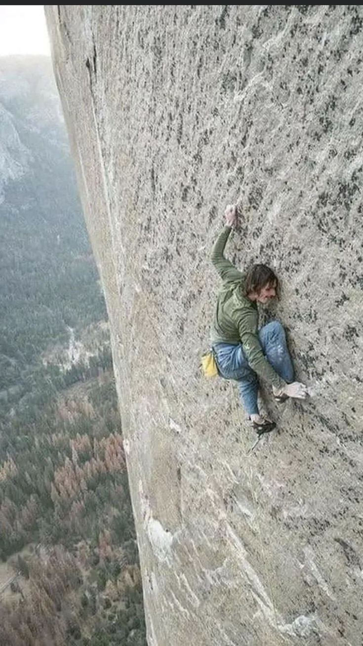 a man climbing up the side of a mountain