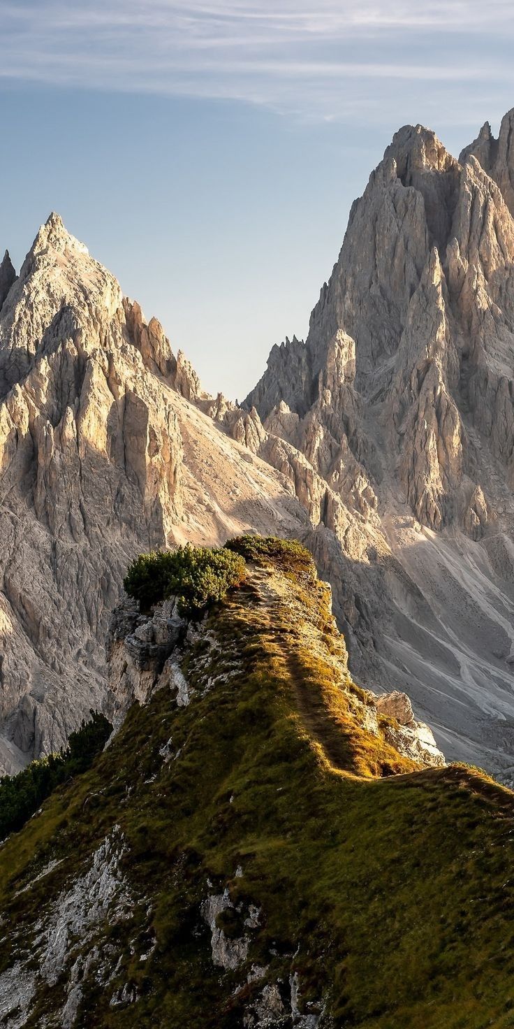 the mountains are covered in green grass and there is a bench on top of it