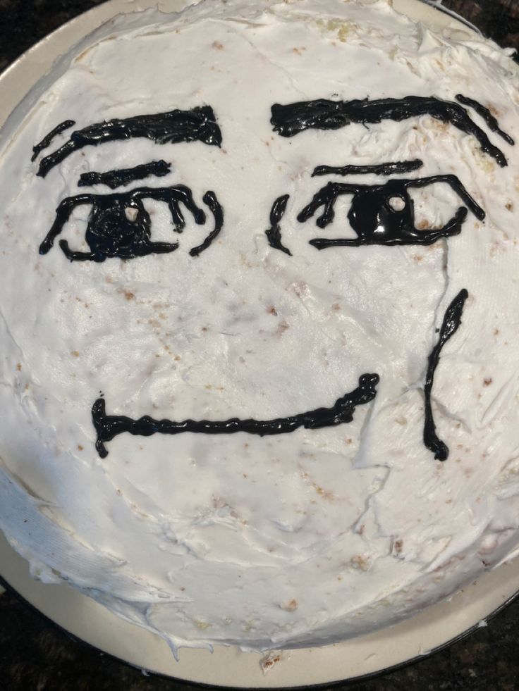 a cake that has been decorated to look like a man's face with black lines on it