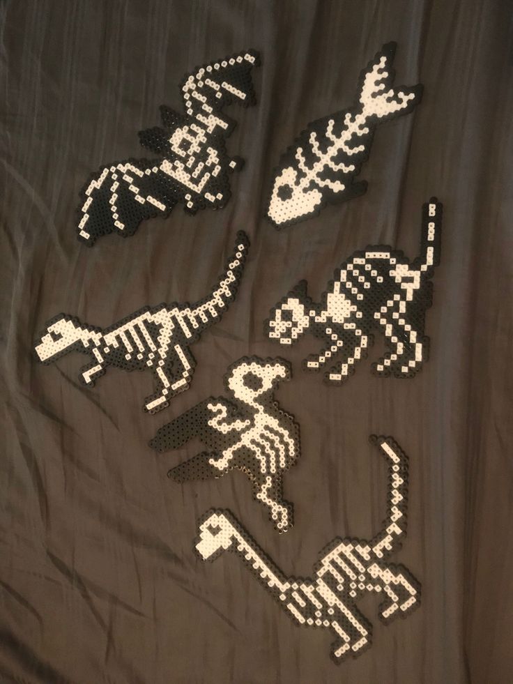 some type of pixel art that looks like animals and skeletons on a sheet with black background