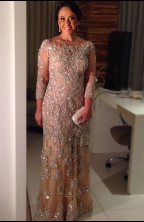 a woman standing in front of a mirror wearing a dress with sequins on it