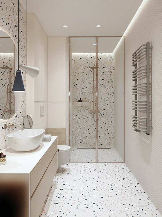 a bathroom with a sink, toilet and shower stall in the middle of the room