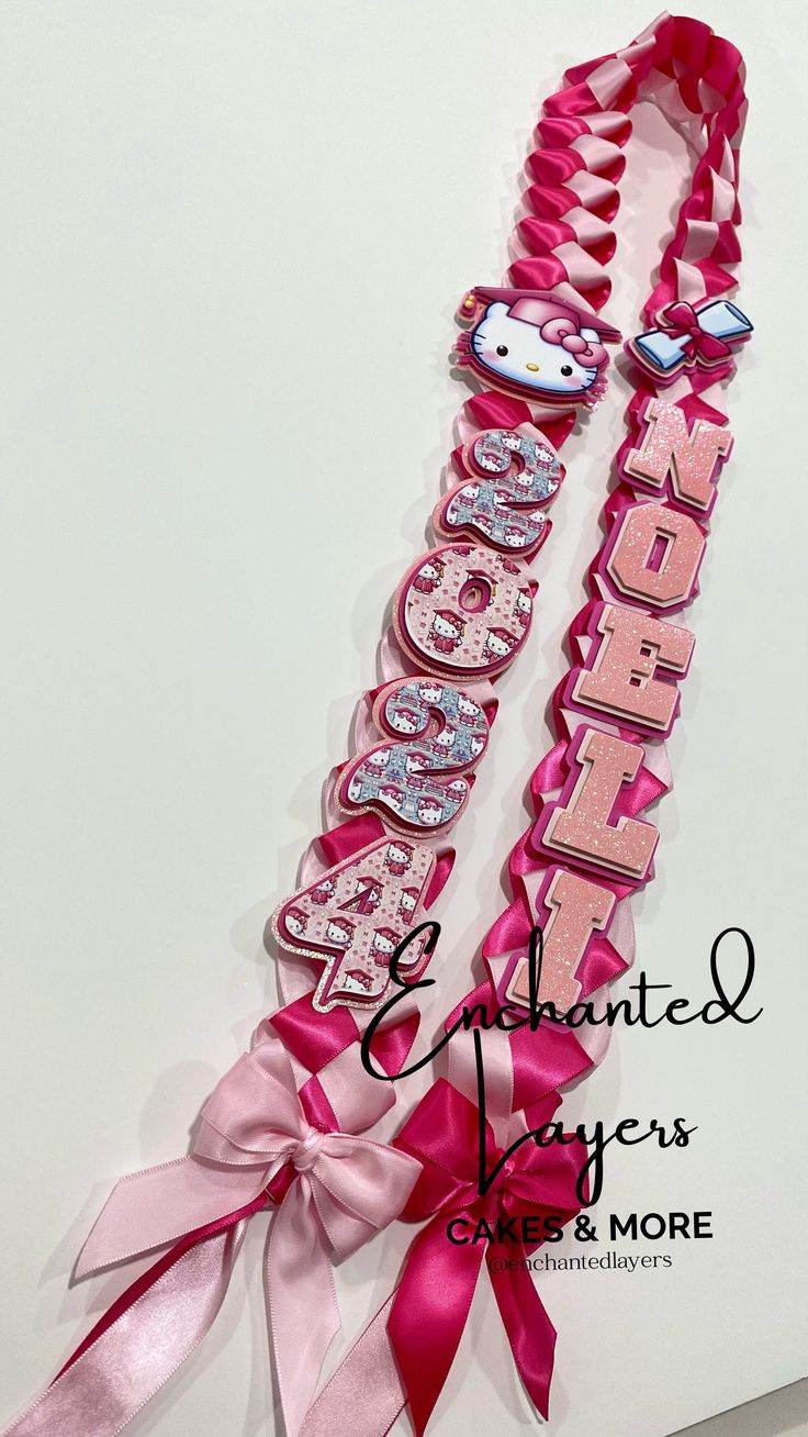 two pink hair ties with hello kitty and hello kitty name tags attached to each one