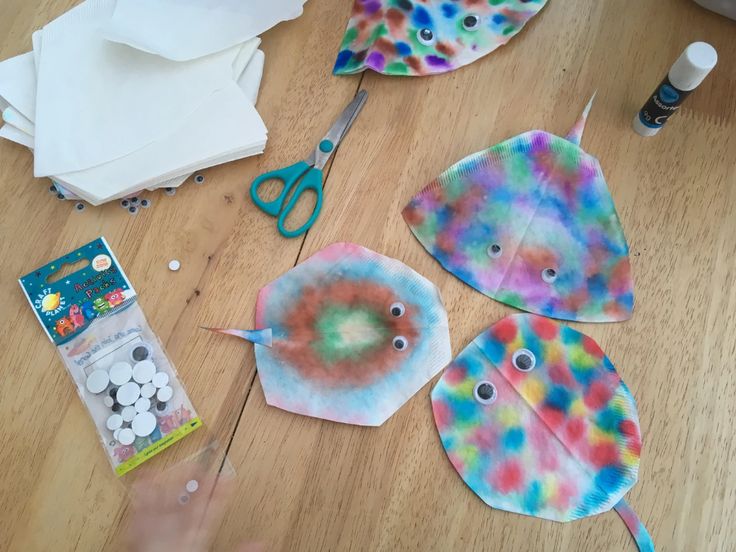 paper plates and scissors on a table with craft supplies