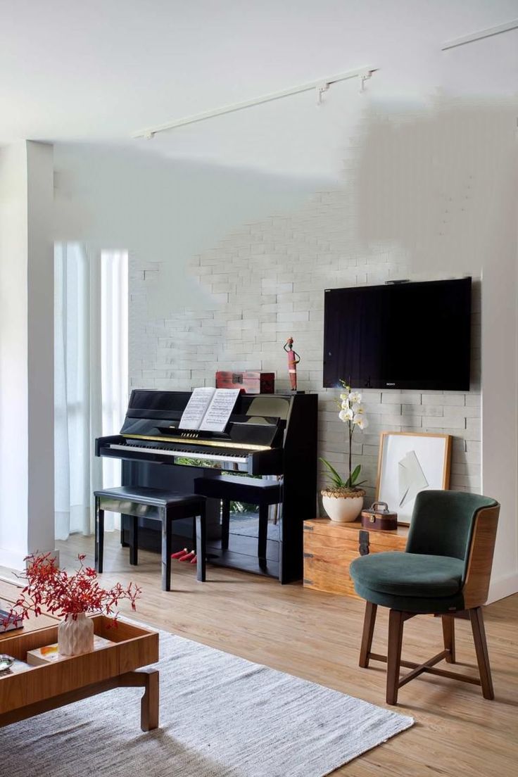 a living room filled with furniture and a flat screen tv mounted to the wall next to a piano