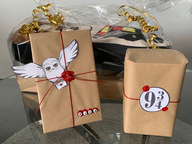 two packages wrapped in brown paper and tied with red ribbon sitting on a glass table