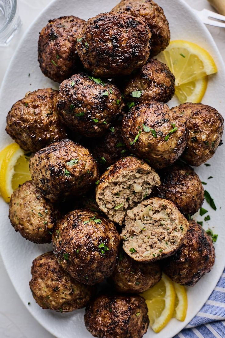 meatballs on a plate with lemon wedges