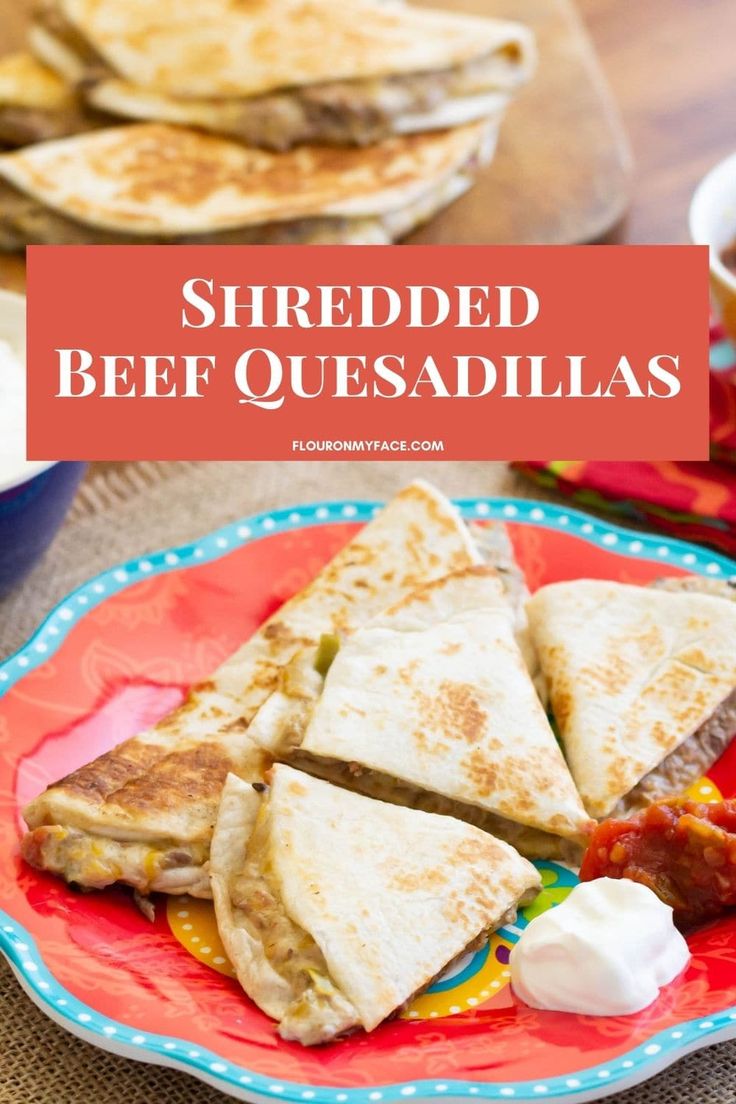 grilled beef quesadillas on a plate with sour cream and salsa in the background