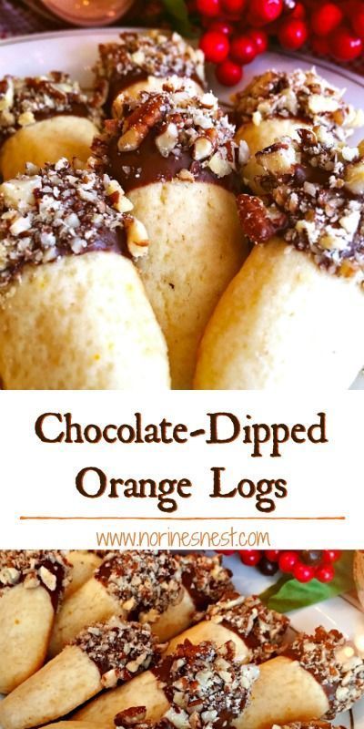 chocolate - dipped orange logs on a white plate with cranberries and christmas decorations in the background