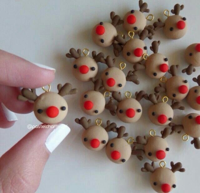 a hand is holding a bunch of tiny christmas reindeers with red noses and nose rings