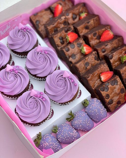 a box filled with lots of different types of cupcakes