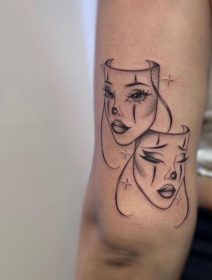 a woman's arm with two faces on it, and one is drawn in black ink