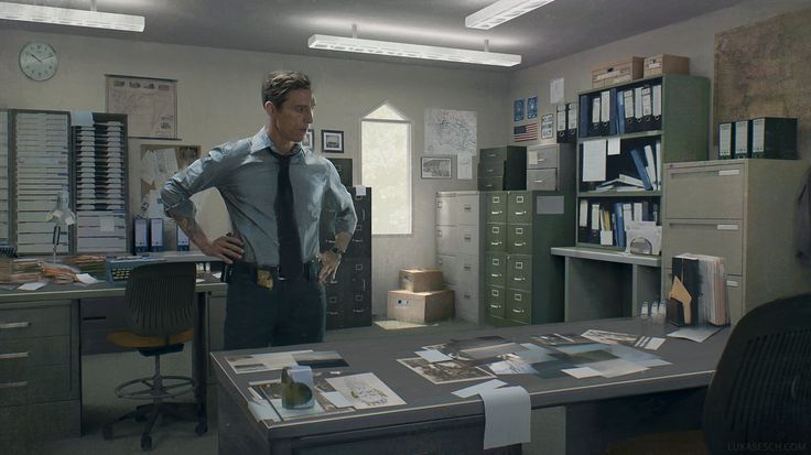 a man standing in an office with his hands on his hips