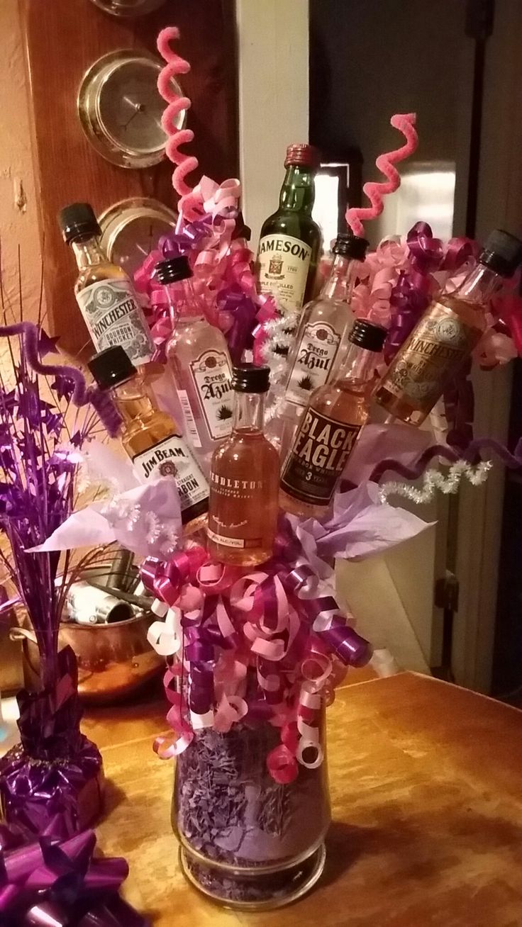 a vase filled with liquor bottles on top of a table