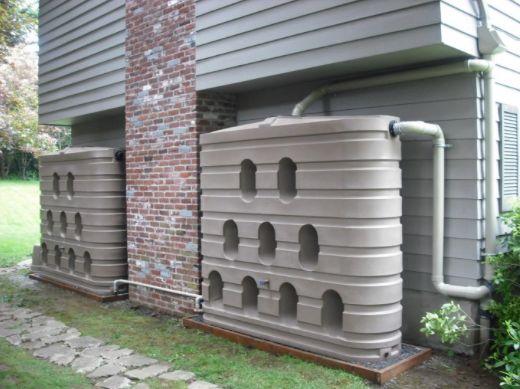 two large metal tanks sitting next to each other on the side of a house in front of a brick building