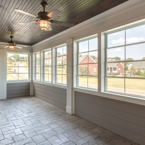 an empty room with large windows and tile flooring on the side of the wall