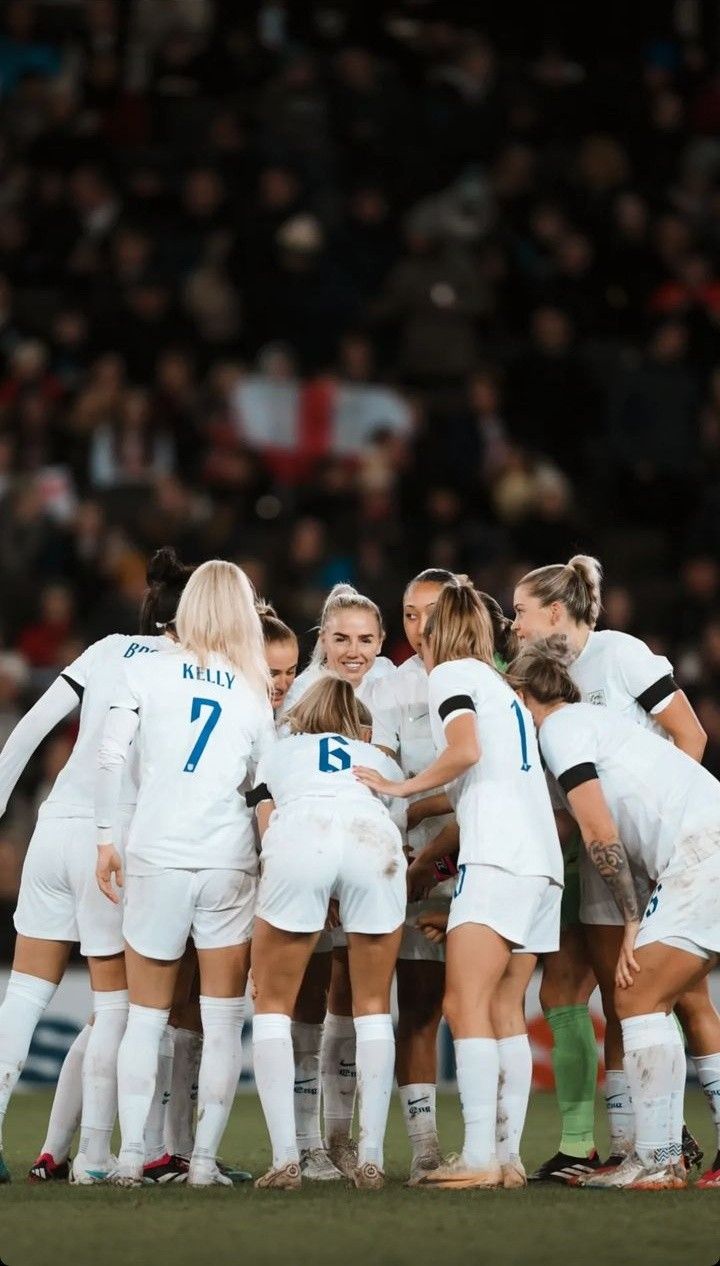 a group of women's soccer players huddle together