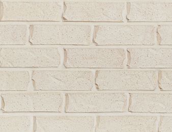 a white brick wall that is very close to the ground