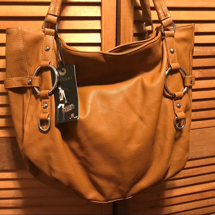 Tan Faux Leather Shoulder Bag With Silver-Tone Hardware, Zippered Top For Closure, Zippered Back Pocket, Cloth Lining With A Zippered Pocket On One Side And 2 Open Pockets On The Other Side. Measures 16” Wide X 13” Tall X 5” Wide Bottom. Nwt. Other Than Minor Peeling On The Straps As Shown In The Last Picture, This Bag Is In Excellent Condition. Leather Hobo Bag With Hasp Closure, Everyday Faux Leather Satchel With Hasp Closure, Faux Leather Satchel With Hasp Closure For Everyday, Faux Leather Bags With Hasp Closure For Shopping, Leather Hobo Bag With Hasp Closure For Travel, Leather Hobo Bag With Hasp Closure For Everyday, Trendy Leather Hobo Bag With Hasp Closure, Faux Leather Satchel With Handles For Errands, Leather Satchel With Hasp Closure For Shopping