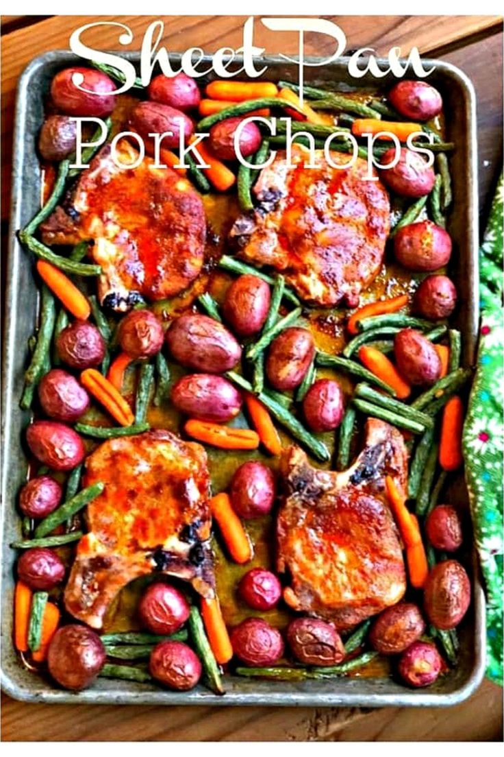 a pan filled with meat and veggies on top of a wooden table next to a green cloth